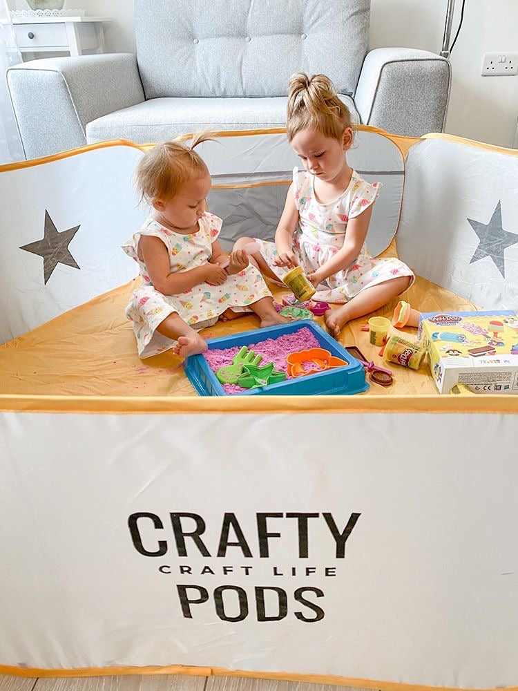 Two sisters in matching dresses playing with playdough in a Crafty Pod