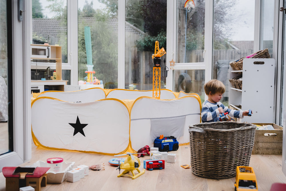 Child playing with all of their toys and a Crafty Pod in a Conservatory